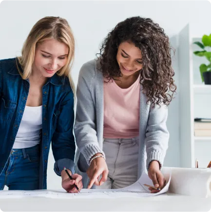Two women reviewing a table blueprint