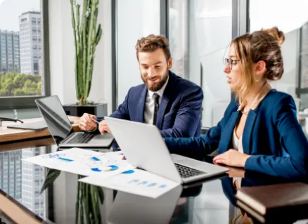 professionals collaborating at a table with laptops